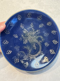 Four Chinese famille rose saucers and a gilt-decorated powder-blue-ground saucer, Qianlong and Jiaqing marks, 18/19th C.