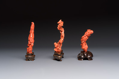 Three Chinese red coral carvings on wooden stands, 19/20th C.