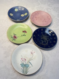 Four Chinese famille rose saucers and a gilt-decorated powder-blue-ground saucer, Qianlong and Jiaqing marks, 18/19th C.