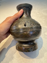 A miniature Chinese archaic bronze wine vessel with Taotie handles, 'Hu 壺', Han