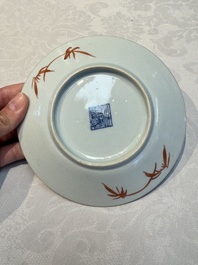 Four Chinese famille rose saucers and a gilt-decorated powder-blue-ground saucer, Qianlong and Jiaqing marks, 18/19th C.