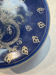Four Chinese famille rose saucers and a gilt-decorated powder-blue-ground saucer, Qianlong and Jiaqing marks, 18/19th C.