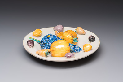 An unusual polychrome Swiss faience trompe l'oeil dish with various fruits, Winterthur, workshop of David Pfau II, 17th C.
