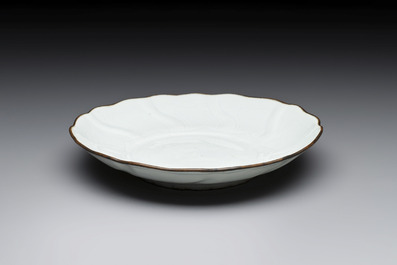 A Chinese moulded white-glazed plate with anhua floral design and a copper-mounted rim, Xuande mark, late Ming