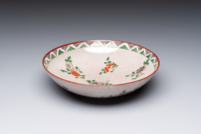 An unusual Chinese famille verte copper-red-ground shallow bowl with floral design, 19th C.