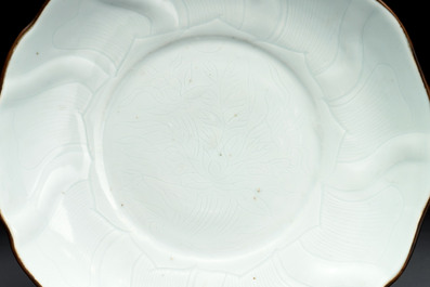 A Chinese moulded white-glazed plate with anhua floral design and a copper-mounted rim, Xuande mark, late Ming