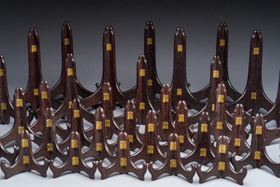 A collection of 35 Chinese wooden folding plate stands, 20th C.