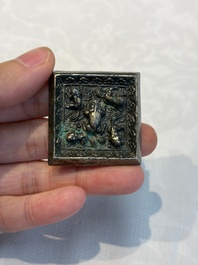 A small Chinese metal-alloy square mirror with relief design, Tang