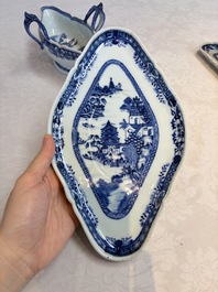 A pair of Chinese blue and white handled sauce boats and stands with pagodas along a river, Qianlong