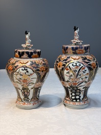 A pair of Japanese Imari baluster vases and covers on wooden stands, Edo, 18th C.