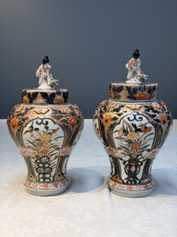 A pair of Japanese Imari baluster vases and covers on wooden stands, Edo, 18th C.