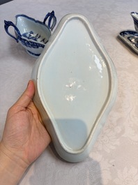 A pair of Chinese blue and white handled sauce boats and stands with pagodas along a river, Qianlong