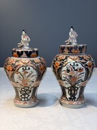A pair of Japanese Imari baluster vases and covers on wooden stands, Edo, 18th C.