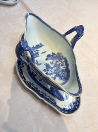 A pair of Chinese blue and white handled sauce boats and stands with pagodas along a river, Qianlong