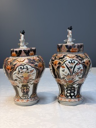 A pair of Japanese Imari baluster vases and covers on wooden stands, Edo, 18th C.