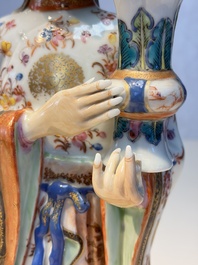 A Chinese famille rose candle holder in the shape of a court lady holding a 'Gu' vase, Qianlong