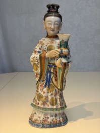 A Chinese famille rose candle holder in the shape of a court lady holding a 'Gu' vase, Qianlong