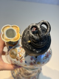 A Chinese famille rose candle holder in the shape of a court lady holding a 'Gu' vase, Qianlong