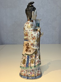 A Chinese famille rose candle holder in the shape of a court lady holding a 'Gu' vase, Qianlong