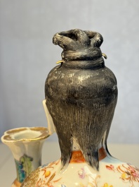 A Chinese famille rose candle holder in the shape of a court lady holding a 'Gu' vase, Qianlong