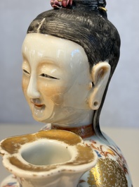 A Chinese famille rose candle holder in the shape of a court lady holding a 'Gu' vase, Qianlong