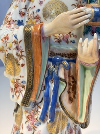 A Chinese famille rose candle holder in the shape of a court lady holding a 'Gu' vase, Qianlong
