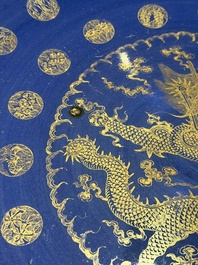 A large Chinese gilt-decorated powder-blue-ground 'Dragon' dish on a later wooden stand, Guangxu mark and of the period