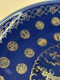 A large Chinese gilt-decorated powder-blue-ground 'Dragon' dish on a later wooden stand, Guangxu mark and of the period