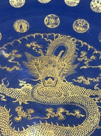A large Chinese gilt-decorated powder-blue-ground 'Dragon' dish on a later wooden stand, Guangxu mark and of the period