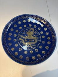 A large Chinese gilt-decorated powder-blue-ground 'Dragon' dish on a later wooden stand, Guangxu mark and of the period