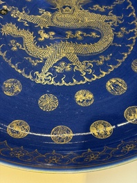 A large Chinese gilt-decorated powder-blue-ground 'Dragon' dish on a later wooden stand, Guangxu mark and of the period