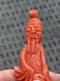 Three Chinese red coral carvings on wooden stands, 19/20th C.
