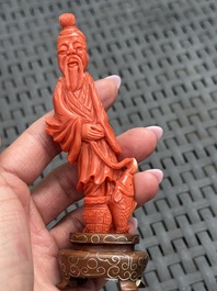 Three Chinese red coral carvings on wooden stands, 19/20th C.