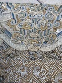 A Chinese cream-ground embroidered silk panel with bats, floral scrolls, waves and rockwork, 19th C.