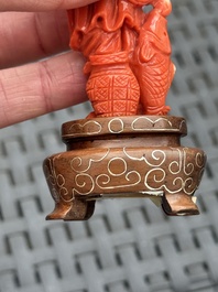 Three Chinese red coral carvings on wooden stands, 19/20th C.