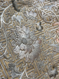 A Chinese cream-ground embroidered silk panel with bats, floral scrolls, waves and rockwork, 19th C.