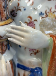 A Chinese famille rose candle holder in the shape of a court lady holding a 'Gu' vase, Qianlong