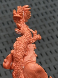 Three Chinese red coral carvings on wooden stands, 19/20th C.