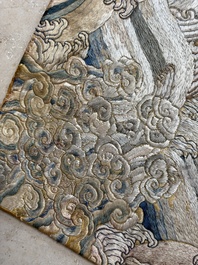 A Chinese cream-ground embroidered silk panel with bats, floral scrolls, waves and rockwork, 19th C.