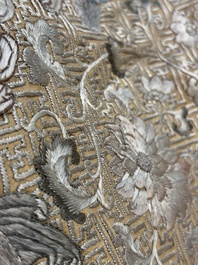 A Chinese cream-ground embroidered silk panel with bats, floral scrolls, waves and rockwork, 19th C.
