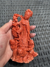A Chinese carved red coral 'Goddess and Boys' group on a wooden stand, 19/20th C.