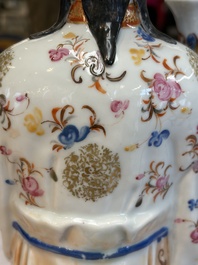 A Chinese famille rose candle holder in the shape of a court lady holding a 'Gu' vase, Qianlong