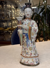 A Chinese famille rose candle holder in the shape of a court lady holding a 'Gu' vase, Qianlong