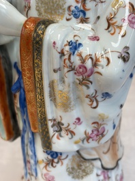 A Chinese famille rose candle holder in the shape of a court lady holding a 'Gu' vase, Qianlong