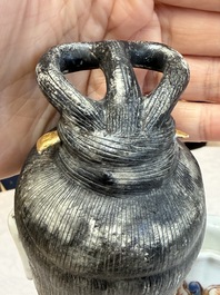 A Chinese famille rose candle holder in the shape of a court lady holding a 'Gu' vase, Qianlong