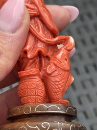 Three Chinese red coral carvings on wooden stands, 19/20th C.