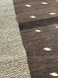 A very large Persian hand-knotted woollen carpet with a geometric patchwork design, 20th C.