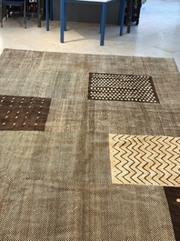 A large Persian hand-knotted woollen carpet with a geometric patchwork design, 20th C.