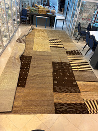 A very large Persian hand-knotted woollen carpet with a geometric patchwork design, 20th C.