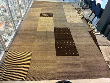 A very large Persian hand-knotted woollen carpet with a geometric patchwork design, 20th C.